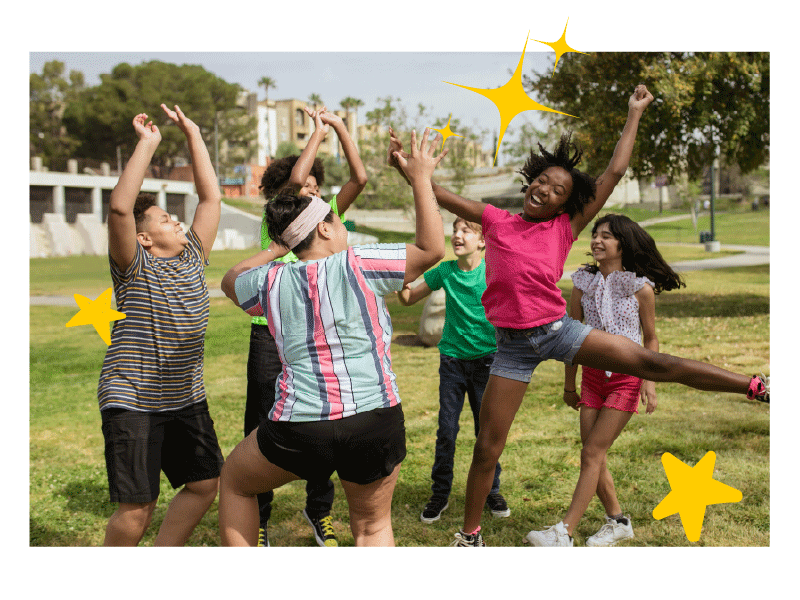 Six kids jump and dance in a tree-lined park. Stars pop up around the photo as the gif plays.